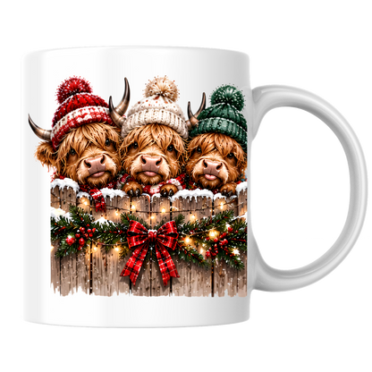 Highland Cows Christmas Fence Mug "Merry & Bright" Festive Highland Cows 325ml Ceramic Coffee Mug – Three Cute Cows in Winter Bobble Hats Behind Snowy Fence with Fairy Lights & Red Tartan Bow | Christmas Gift | Fast Dispatch by UK Seller (M3429)