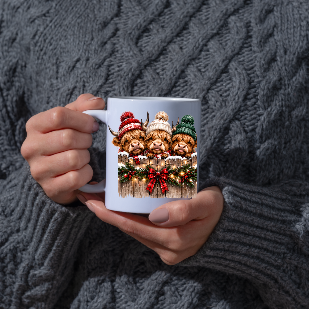 Highland Cows Christmas Fence Mug "Merry & Bright" Festive Highland Cows 325ml Ceramic Coffee Mug – Three Cute Cows in Winter Bobble Hats Behind Snowy Fence with Fairy Lights & Red Tartan Bow | Christmas Gift | Fast Dispatch by UK Seller (M3429)