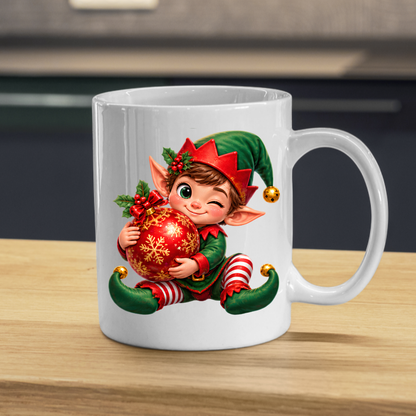 Christmas Mug "Winking Christmas Boy Elf Red Bauble" Winking Christmas Boy Elf 325ml Ceramic Coffee Mug – Cute Festive Tea Cup with Elf Outfit Jingle Bells Snowflake Bauble Graphic Gift | Available in Multicolours | Fast Dispatch by UK Seller (M3186)